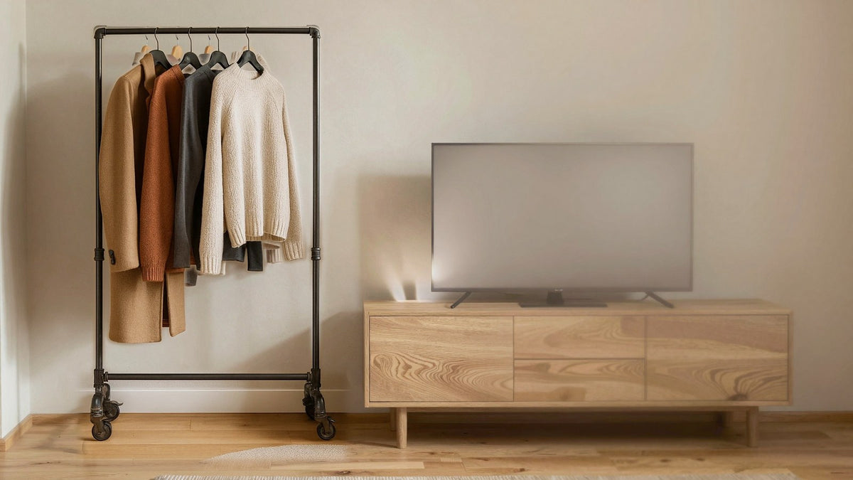Kleiderständer aus Rohr neben einem TV-Sideboard ohne sichtbare Kabel