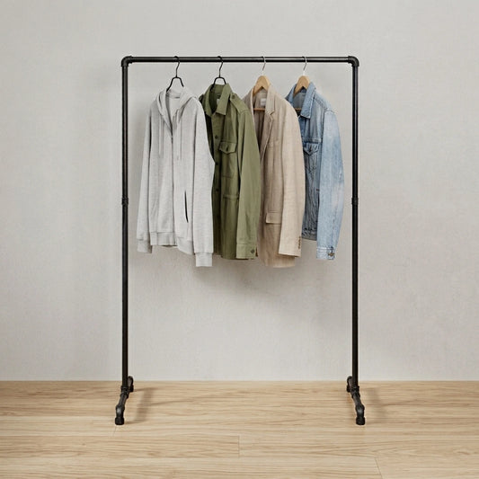 Mia behangen mit Kleidung vor grauer Wand
