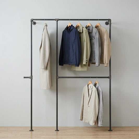 Xaver behangen mit Kleidung an grauer Wand
