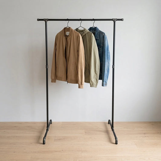 Zoe behangen mit Kleidung vor grauer Wand